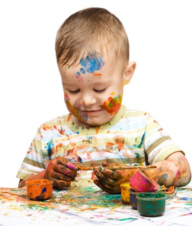 Portrait of a cute little boy messily playing with paints, isolated over white @Serhiy Kobyakov